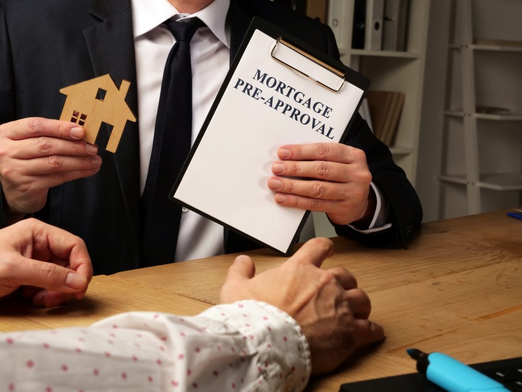 A lending expert holding a mortgage pre-approval clipboard during a consultation, preparing a verified buyer to connect with a trusted real estate professional for a secure home search.